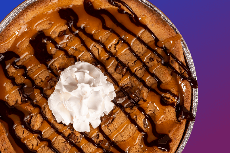 Extra large chocolate cookie with whipped cream and chocolate sauce