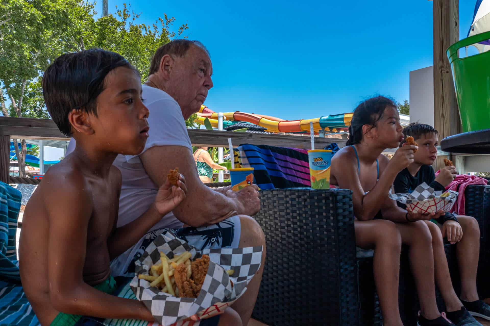 multi generational family eat food in a cabana